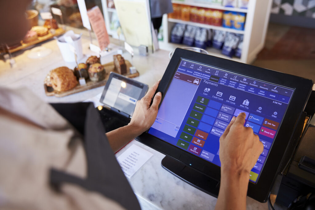 Empleado utilizando un TPV táctil en un comercio para gestionar pagos, ventas y tickets con PixelPOS en Castellón.