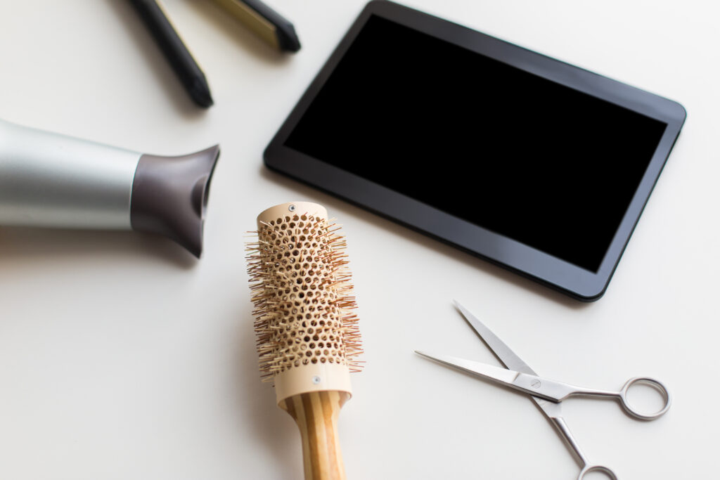 Tablet junto a herramientas de peluquería para gestionar servicios, ventas y caja con PixelPOS en Castellón.