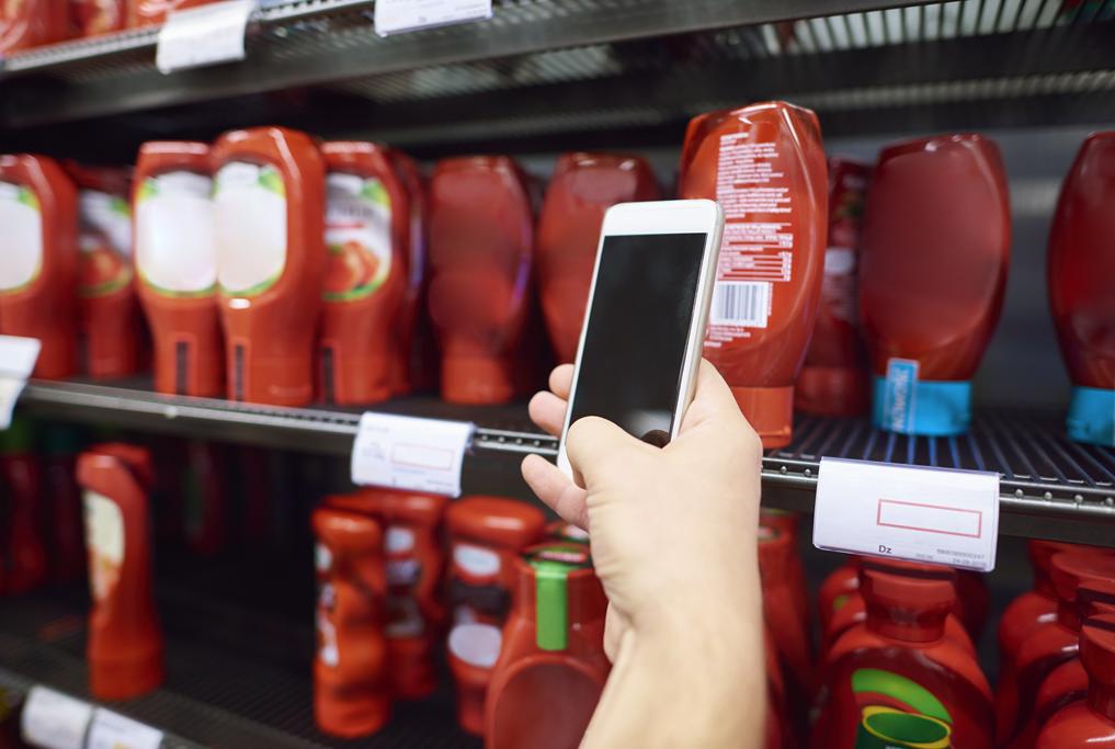 Persona utilizando un móvil en un comercio para revisar productos y organizar categorías con PixelPOS en Castellón.