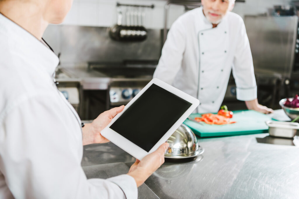 Personal de cocina utilizando una tablet para organizar pedidos y tiempos de preparación con PixelPOS en Castellón.