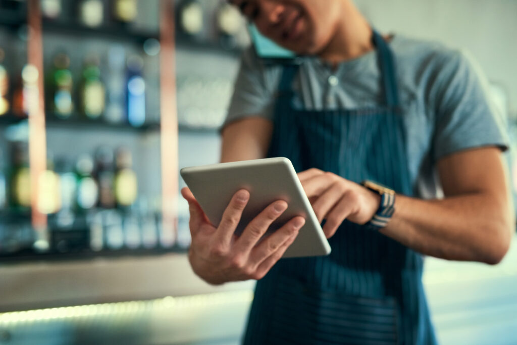 Camarero utilizando una tablet como comandera digital para gestionar pedidos en un restaurante con PixelPOS en Castellón.